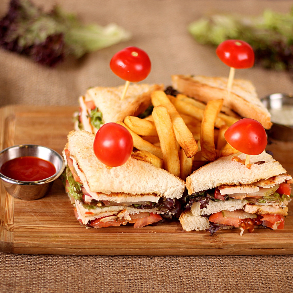 Сэндвичи на доске с картофелем фри и соусом