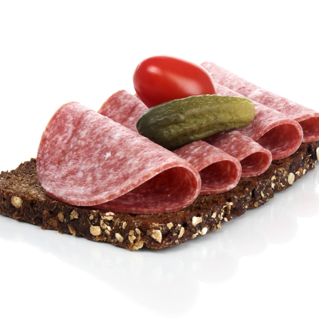 Бутерброд с черным хлебом, колбасой, соленым огурцом и помидором на белом фоне