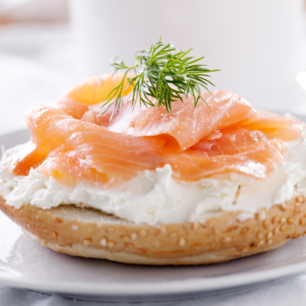 Бутерброд с сыром и красной рыбой на белой тарелке