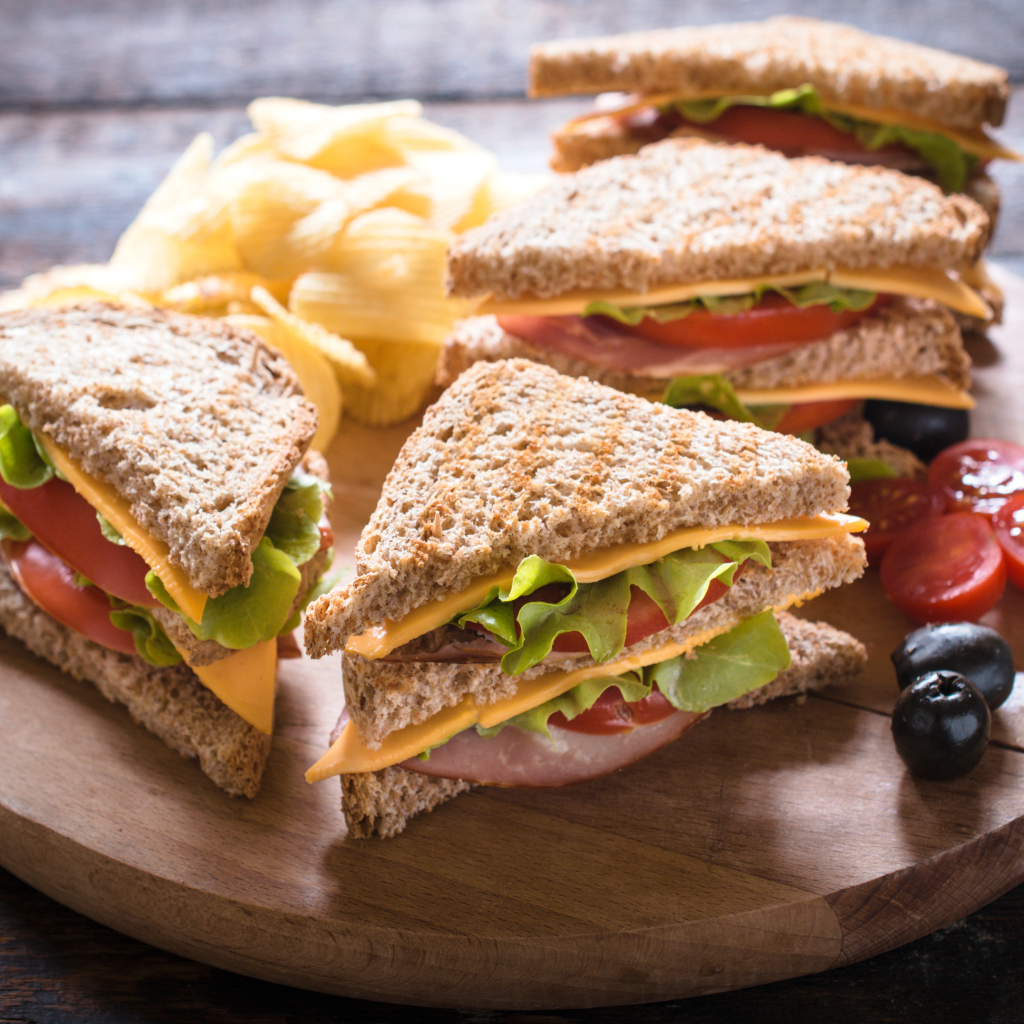 Сэндвичи на деревянной доске с оливками