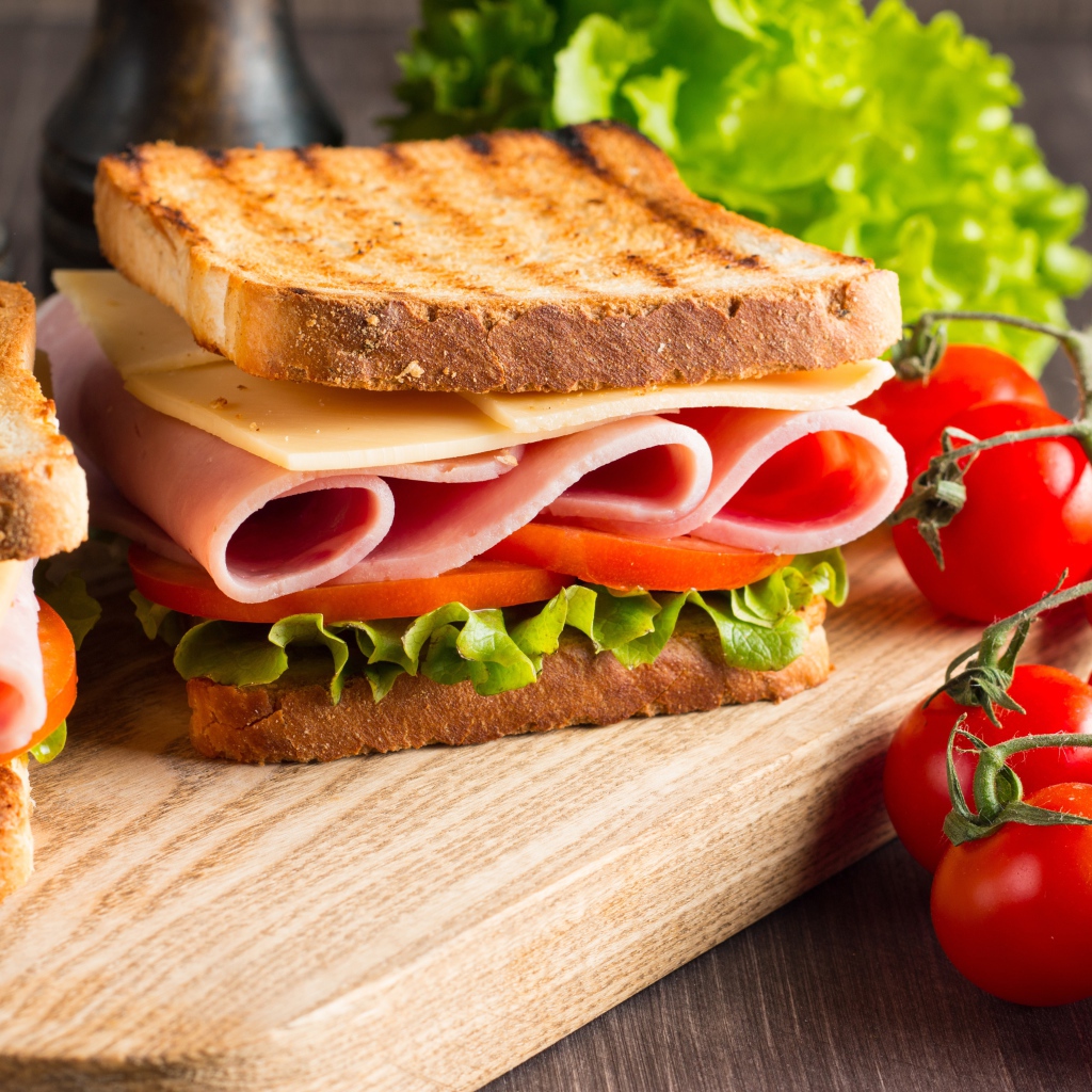 Бутерброды на столе с помидорами и листьями салата