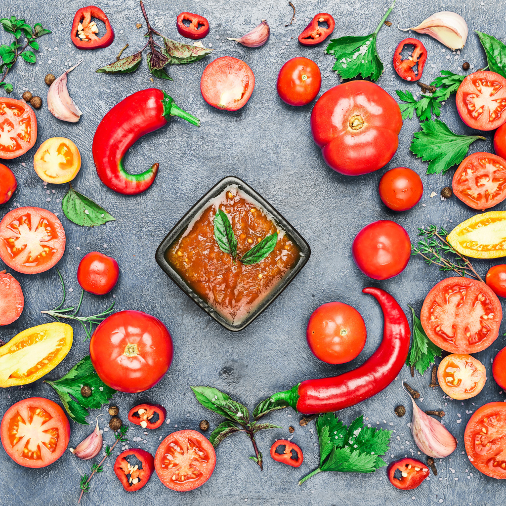 Соус на  сером фоне с овощами, специями и зеленью