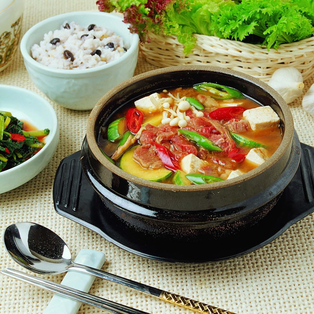 Суп с овощами и мясом на столе с закусками 