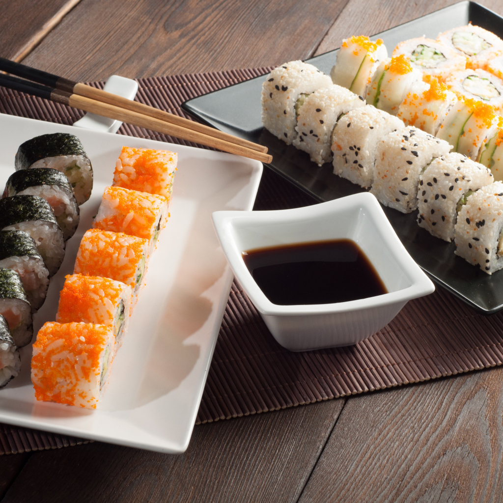Суши на столе с соевым соусом и палочками