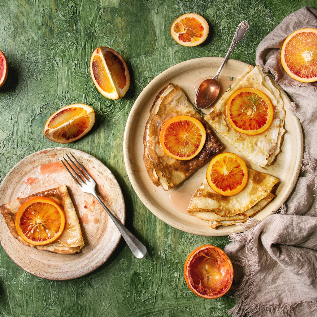 Тонкие блинчики с апельсинами на столе
