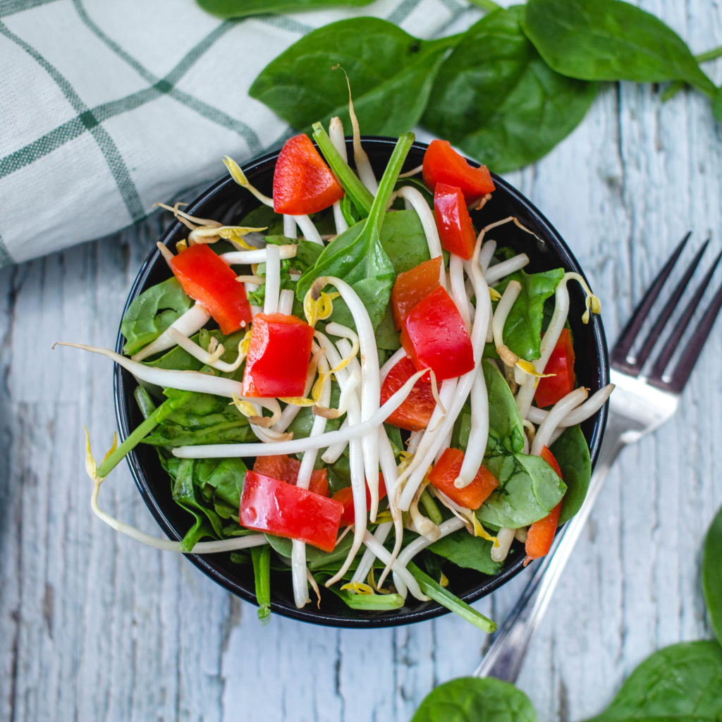 Овощной салат в миске на столе с вилкой