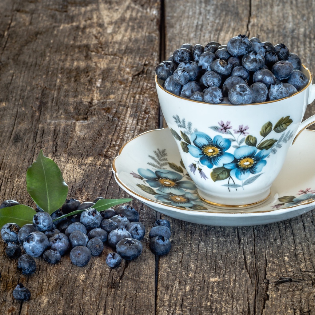 Красивая чашка наполнена ягодами черники