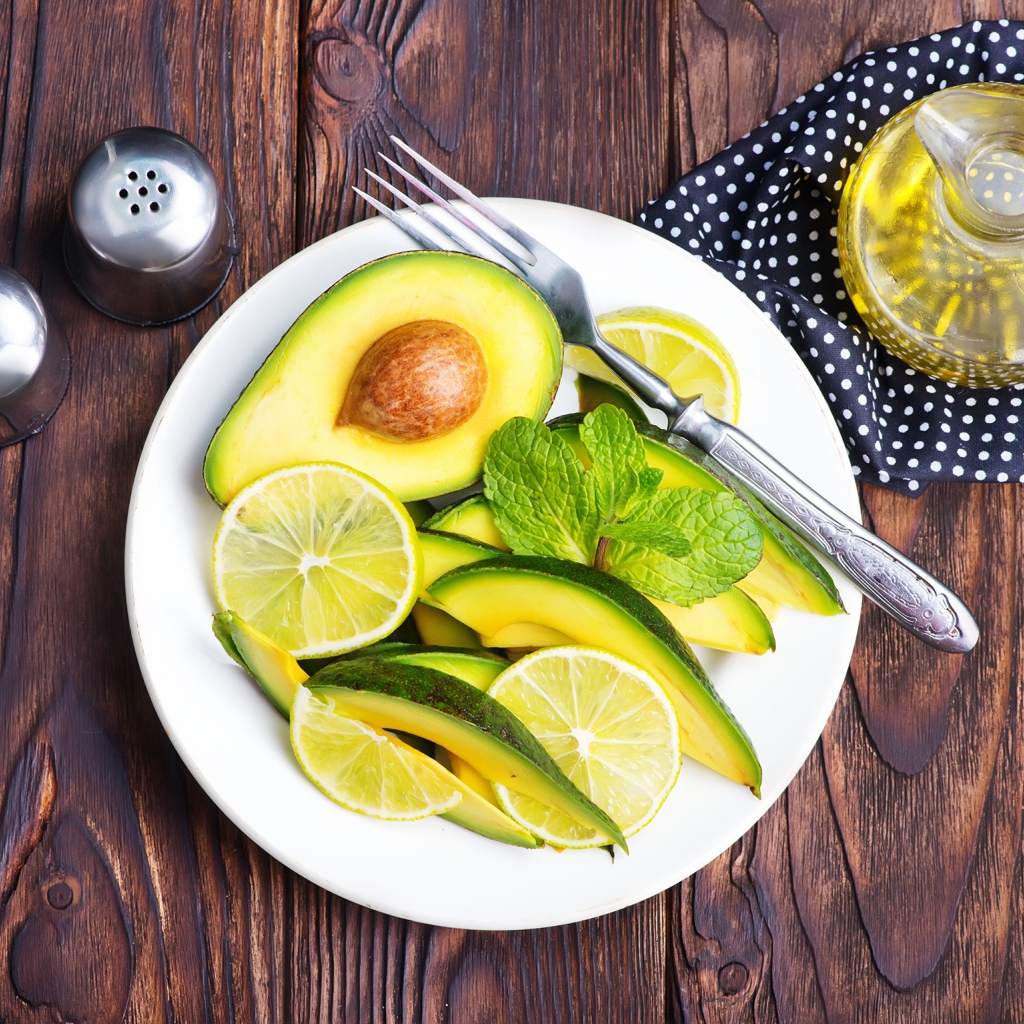 Авокадо и лимон нарезанный кусочками на тарелке
