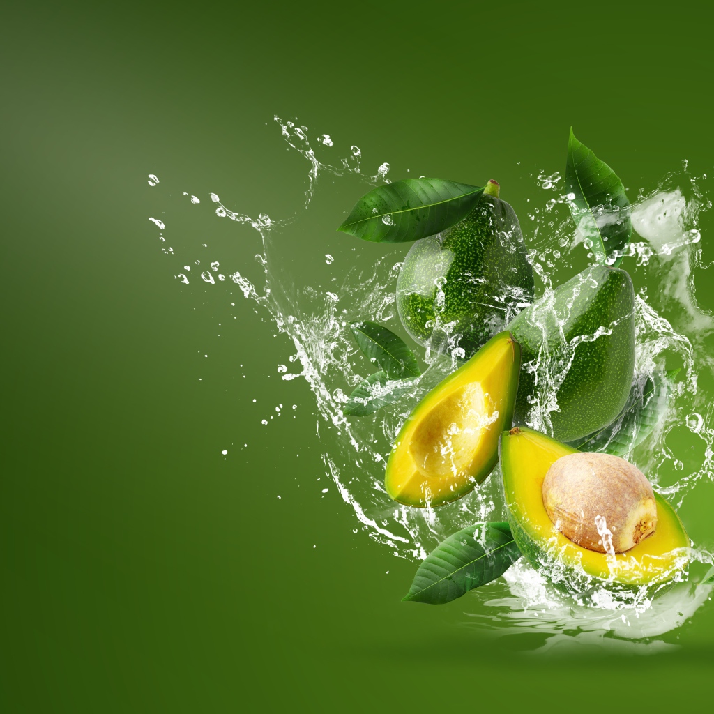 Авокадо в воде на зеленом фоне
