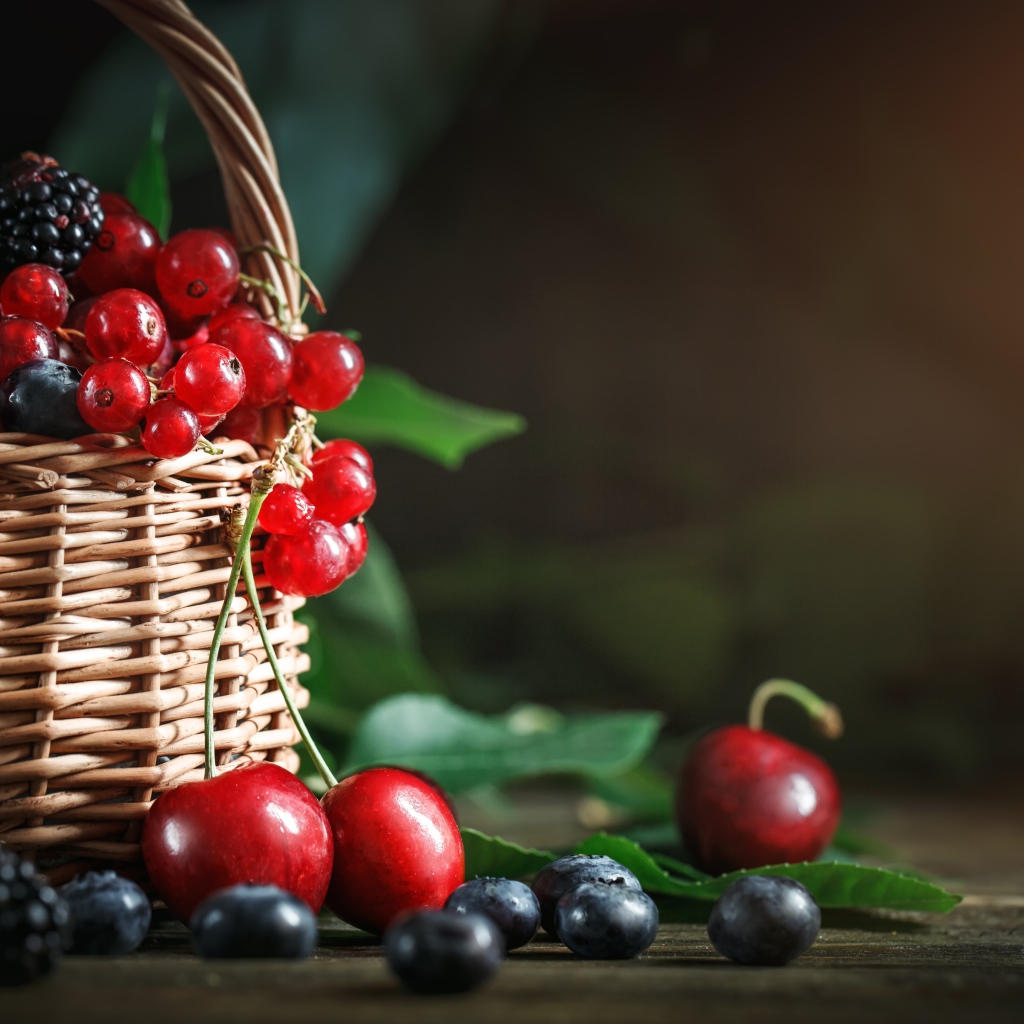 Корзина с ягодами черники, малины, красной смородины и черешни