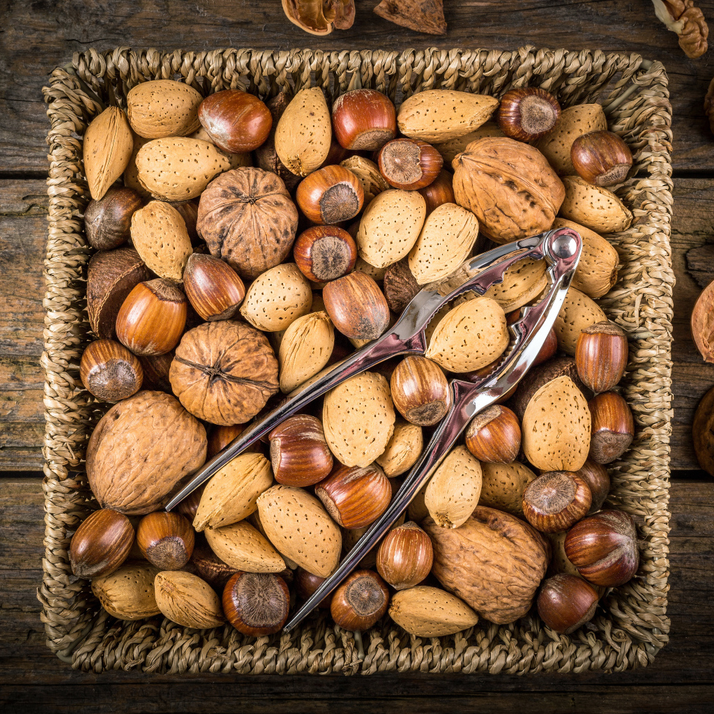Корзина с разными орехами на столе