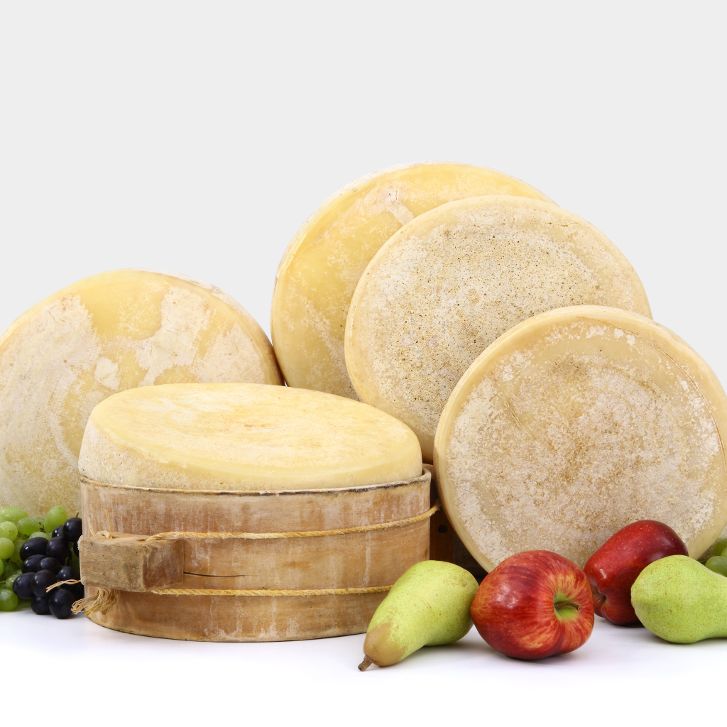 Сыр на столе с грушами, яблоками и виноградом