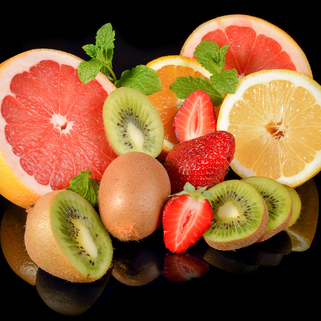 Цитрусовые фрукты на черном фоне с ягодами клубники 