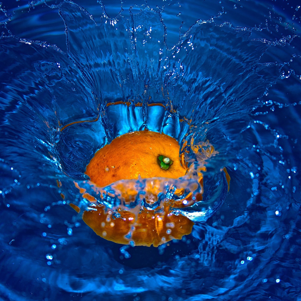 Оранжевый апельсин упал в воду 