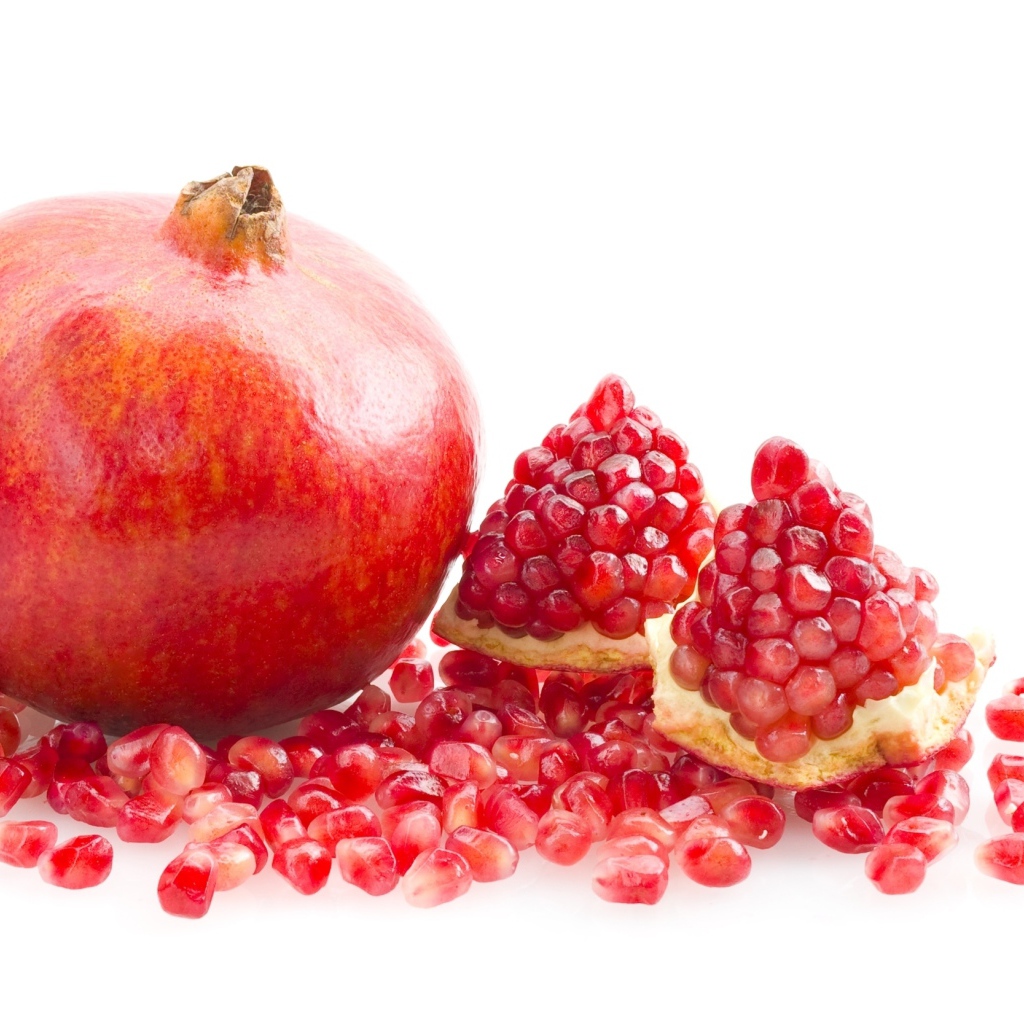 Красный гранат с зернами на белом фоне