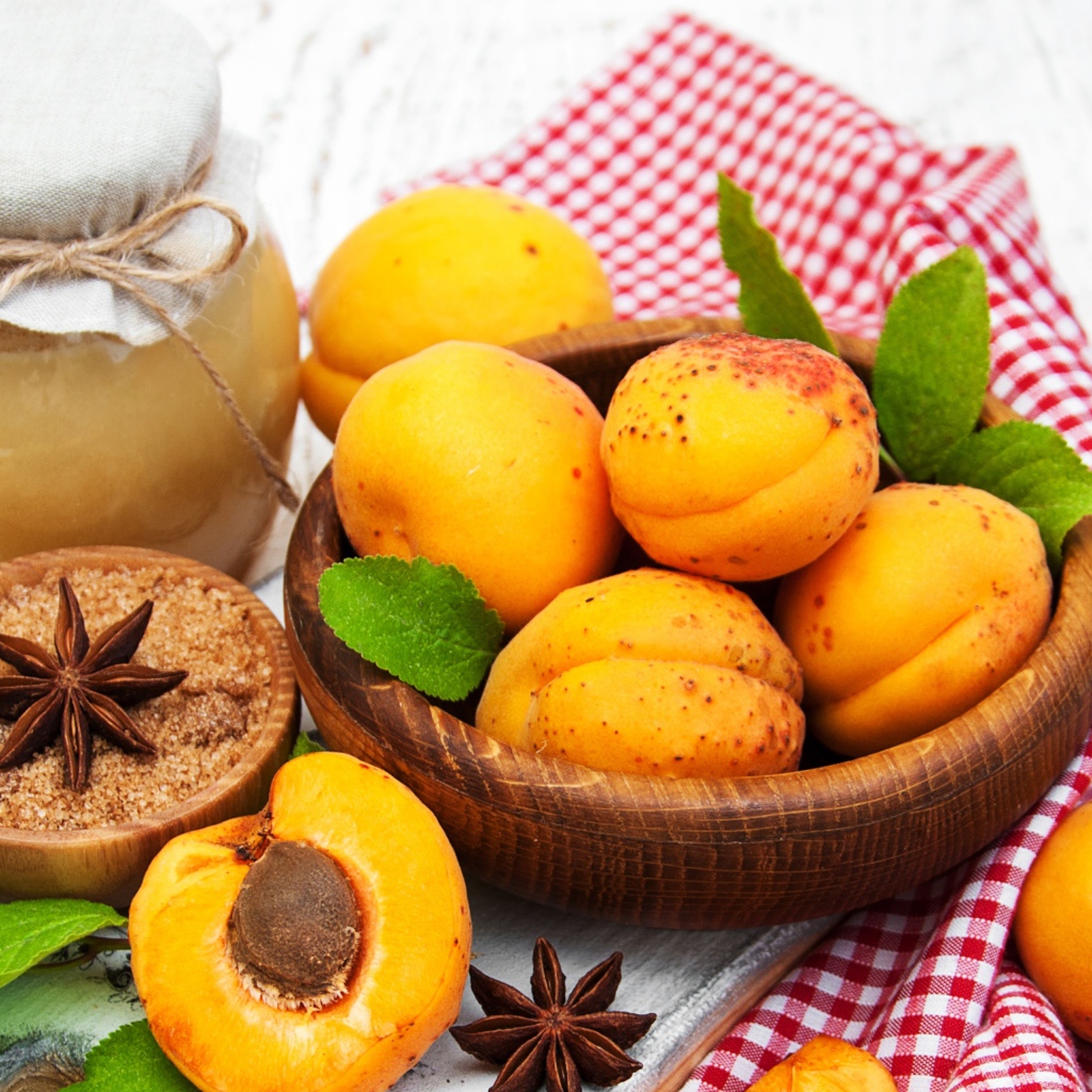 Спелые абрикосы на столе с бадьяном, коричневым сахаром и джемом