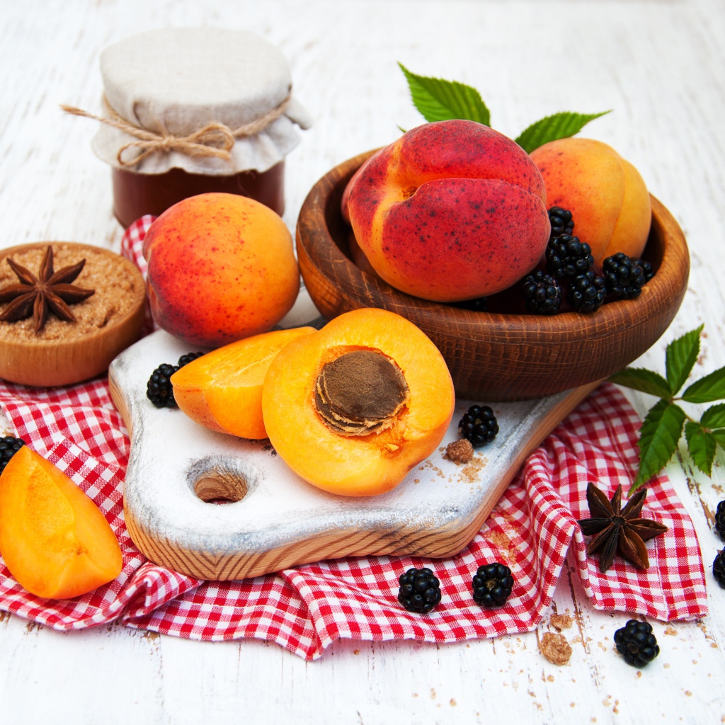 Спелые сочные абрикосы на столе с ягодами черники