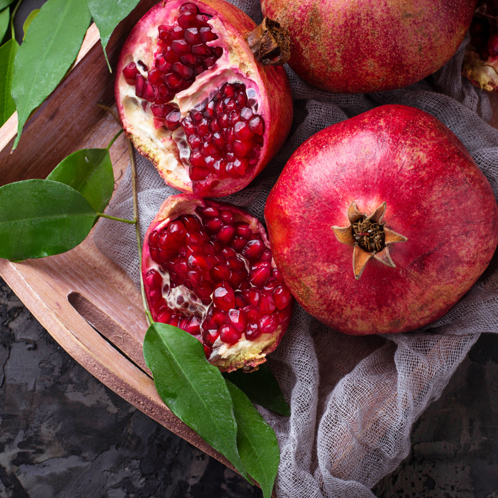 Спелые красные гранаты в деревянном ящике