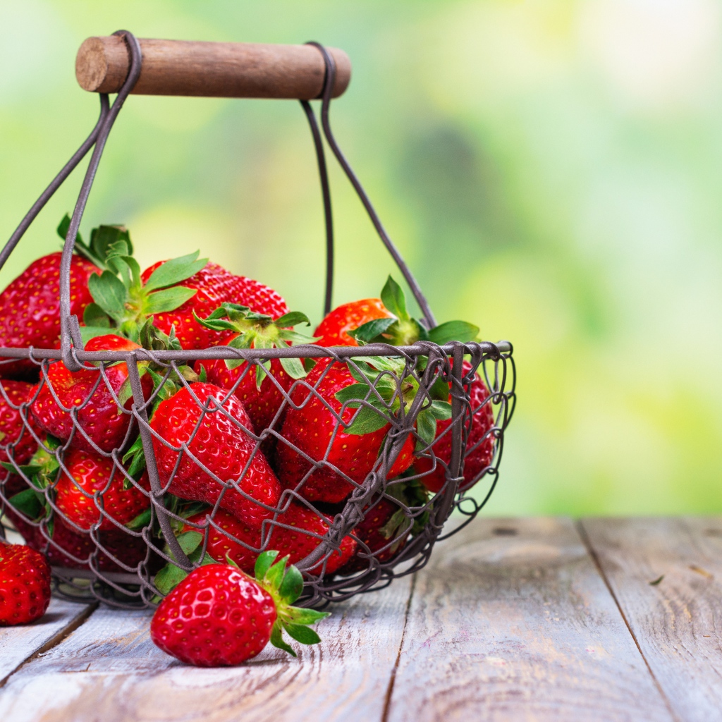 Спелая красная клубника в корзине на столе