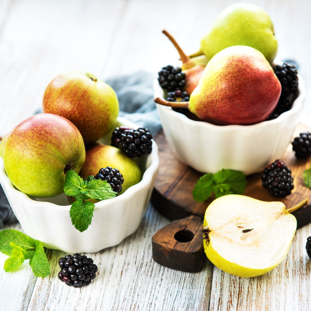 Вкусные груши на столе с ягодами ежевики