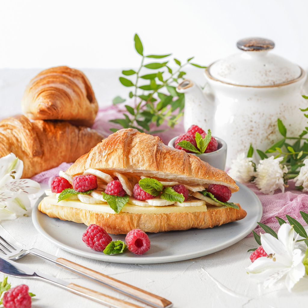 Бутерброд из круассана с ягодами малины и бананами