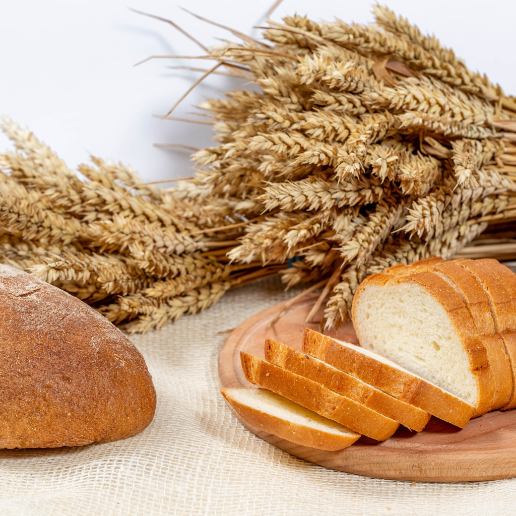 Свежий ароматный хлеб на столе с колосьями пшеницы