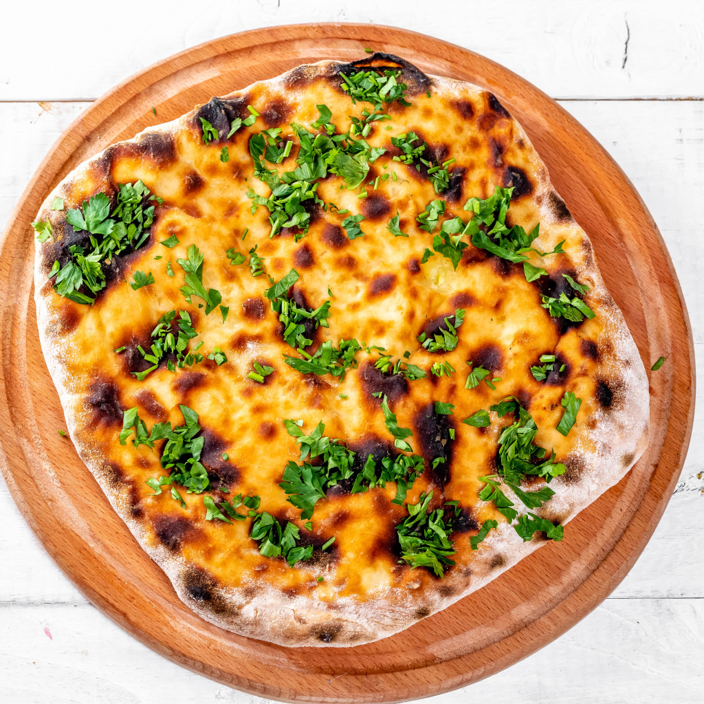 Пирог с сыром и зеленью на доске 