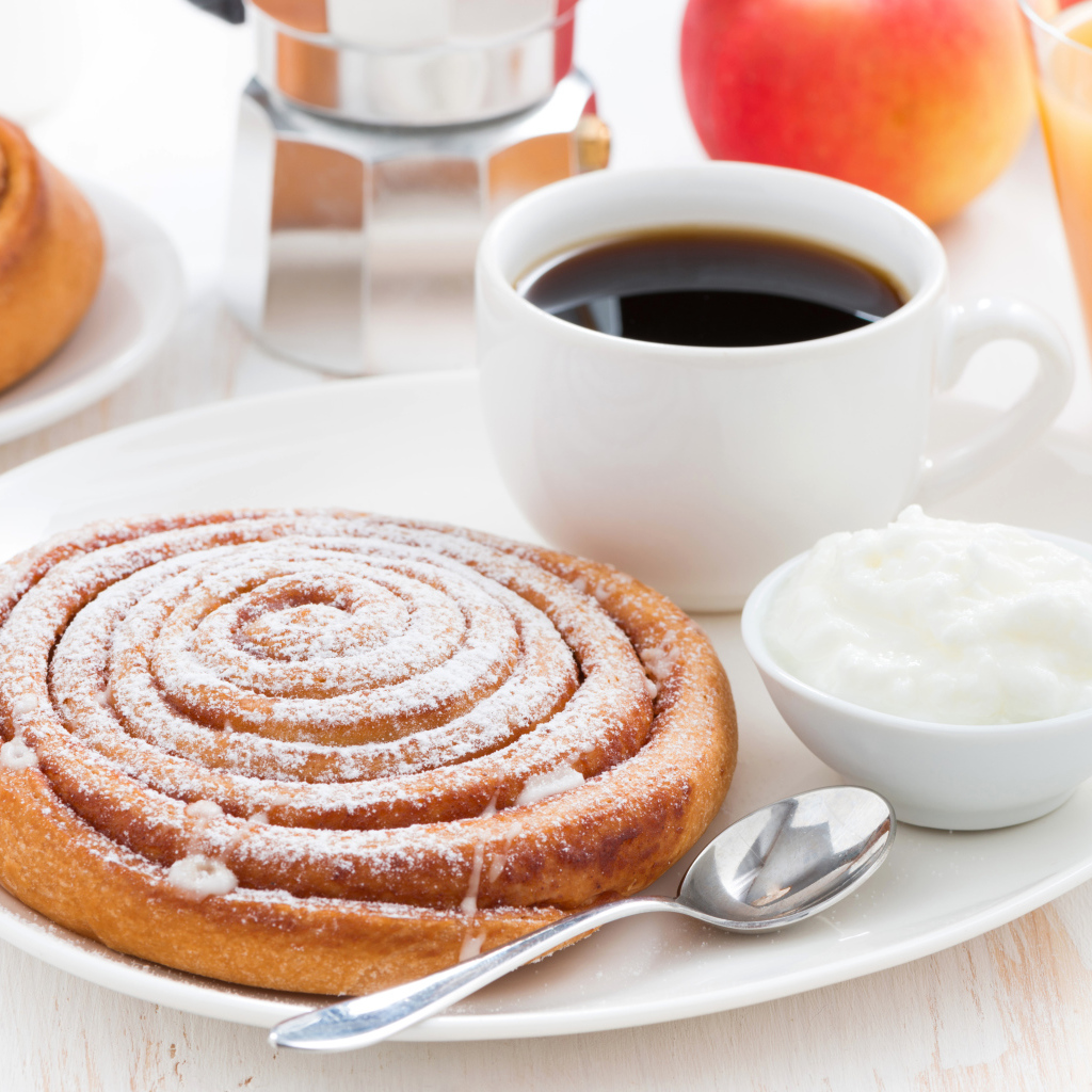 Чашка кофе на тарелке с выпечкой и сливками