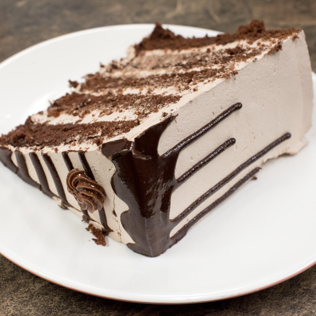 Кусок торта с кремом на белой тарелке