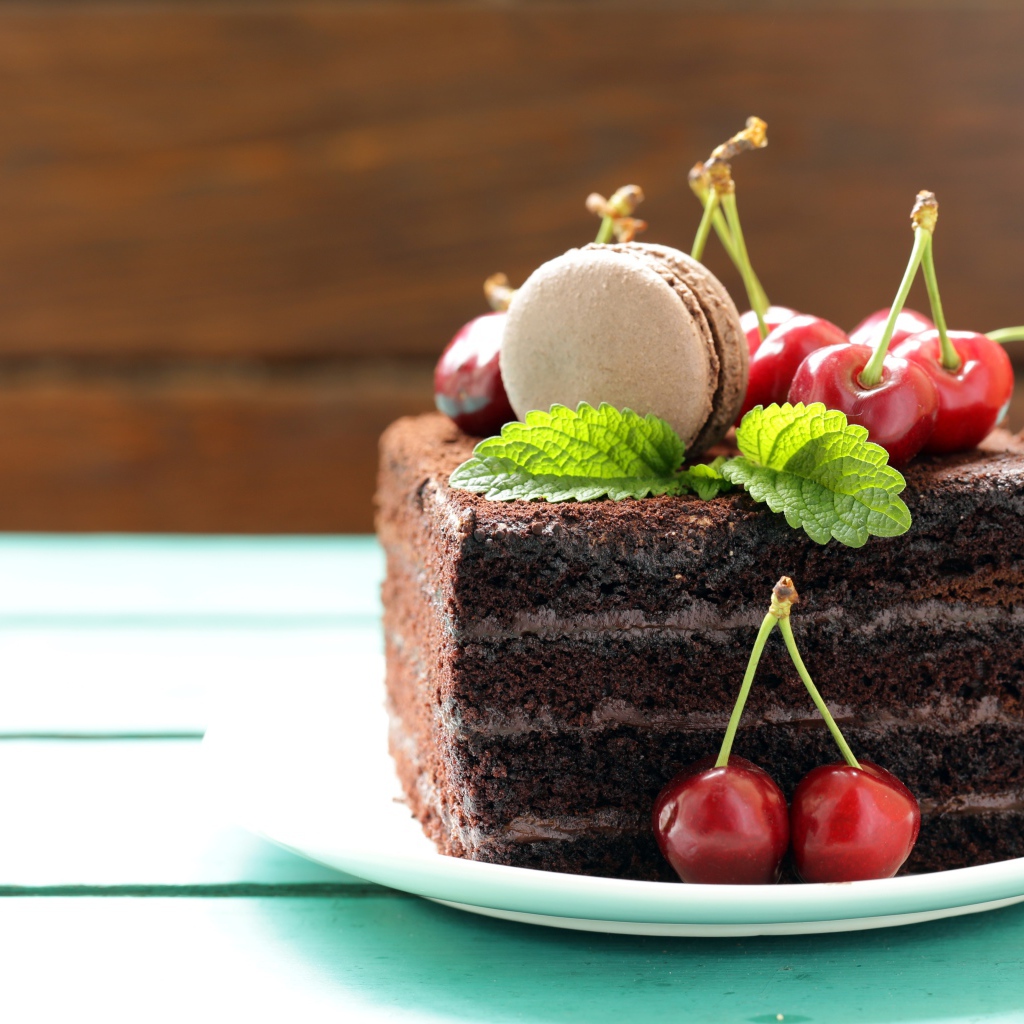 Кусок шоколадного торта с черешней и печеньем макарон