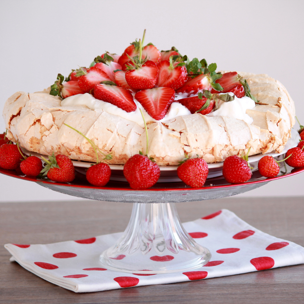 Аппетитный десерт Павлова на блюде с клубникой