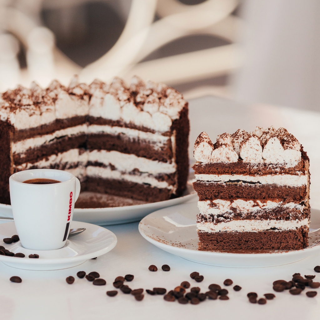 Аппетитный торт с чашкой кофе на столе