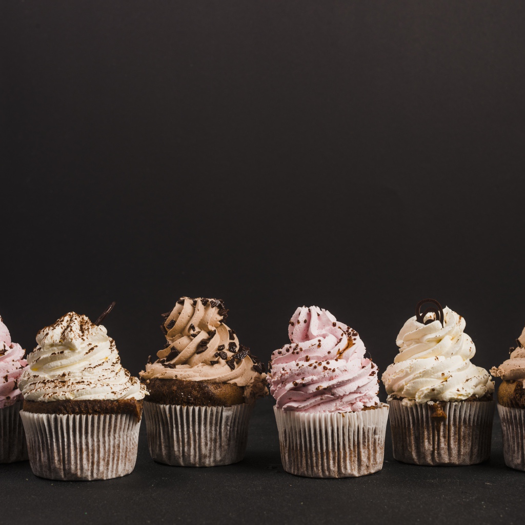 Аппетитные кексы с кремом на сером фоне