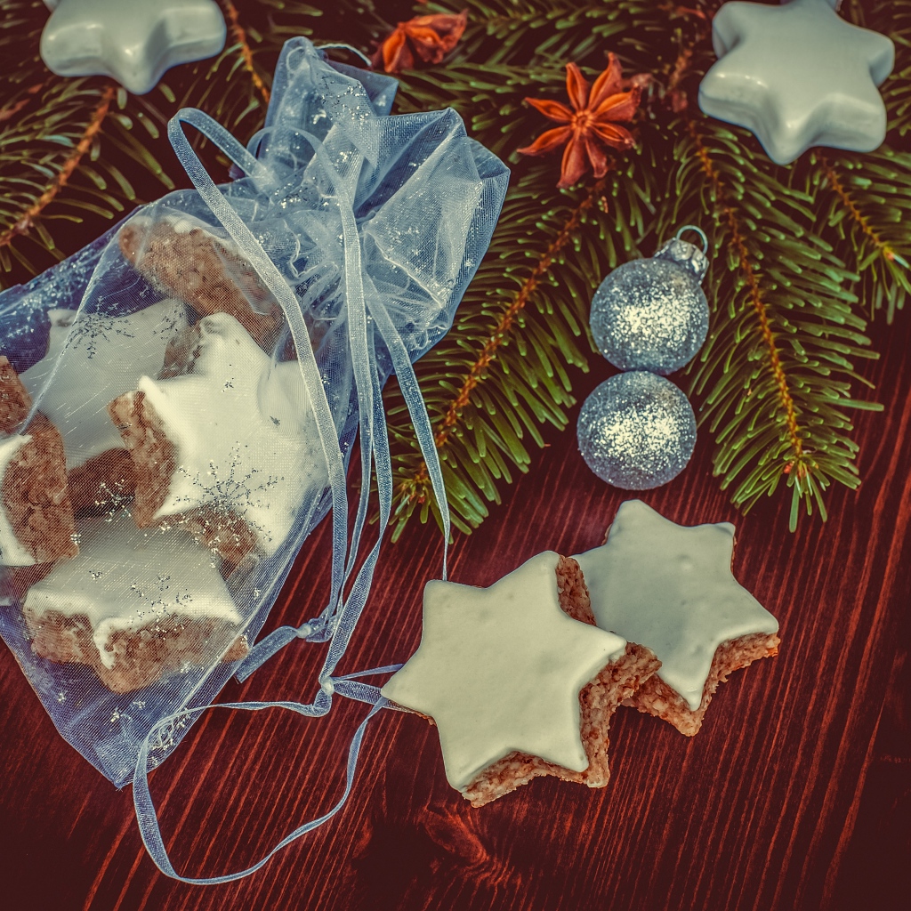 Аппетитное печенье звездочки в мешочке на столе с еловой веткой