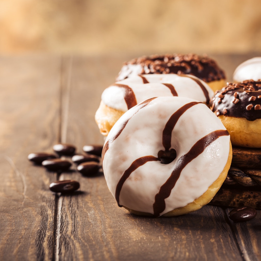 Аппетитные сладкие пончики с глазурью на столе