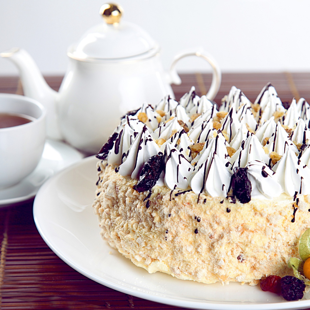 Красивый праздничный торт с безе на столе с чаем