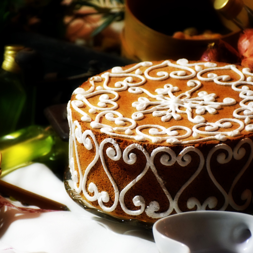 Красивый торт с белым рисунком  на столе