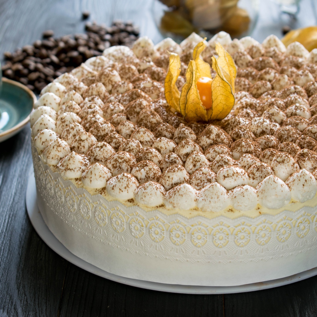 Красивый праздничный торт с цветком физалиса на столе с кофе