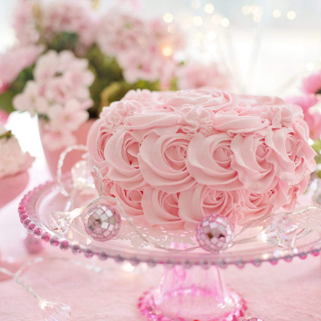 Красивый розовый торт на столе с цветами