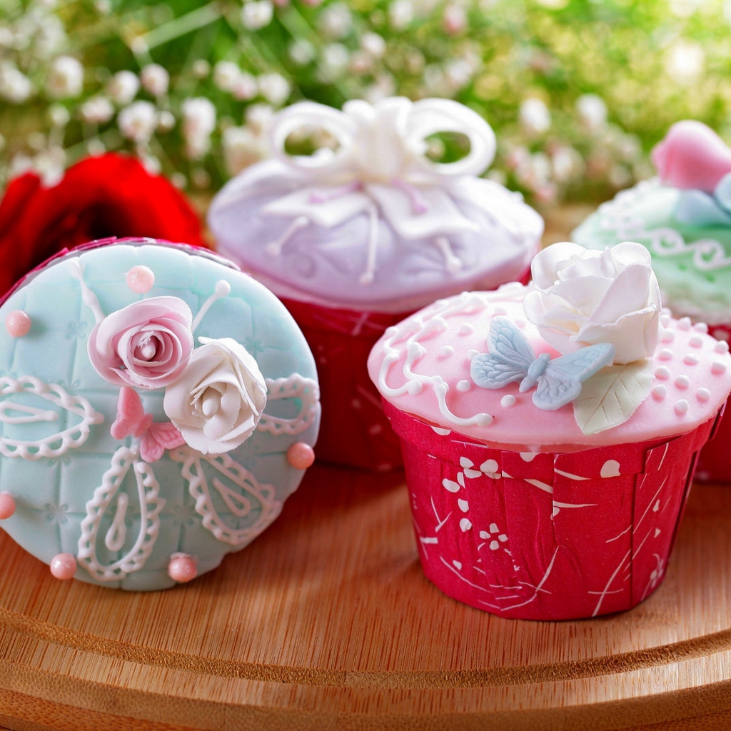 Красиво украшенные кексы на доске с цветами