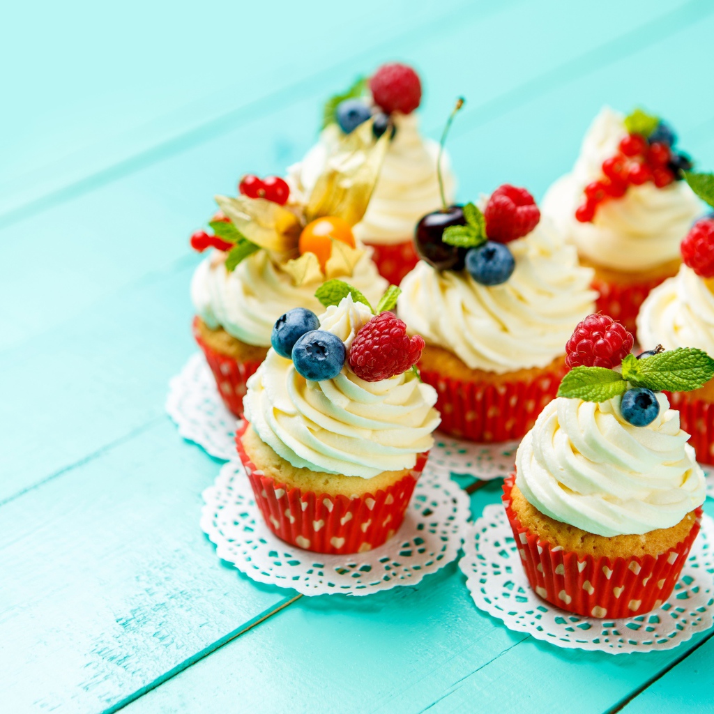 Кексы со взбитыми сливками украшены ягодами