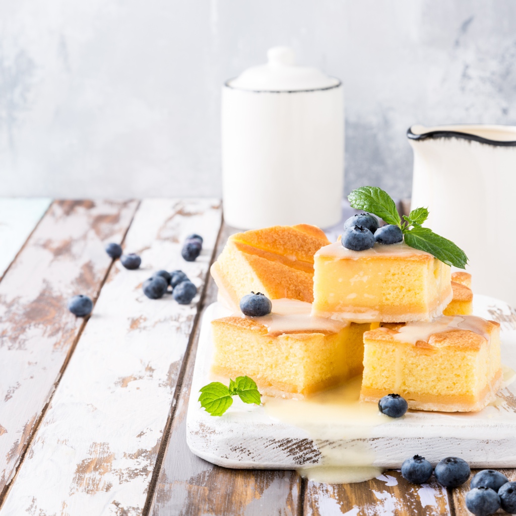 Кусочки бисквитного пирожного на столе с ягодами черники