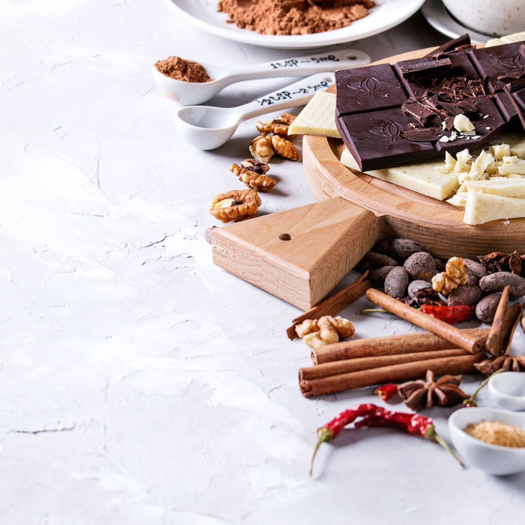 Черный и молочный шоколад на столе с орехами