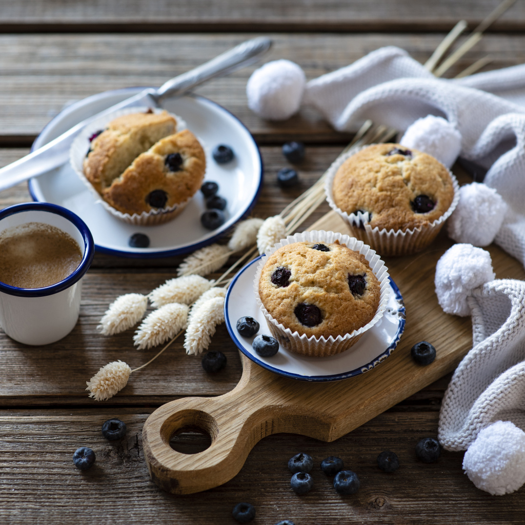 Кексы с черникой на столе с колосьями и кофе