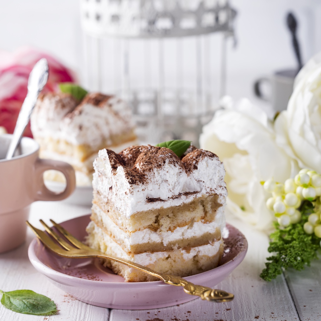 Пирожное на столе с кофе и цветами 