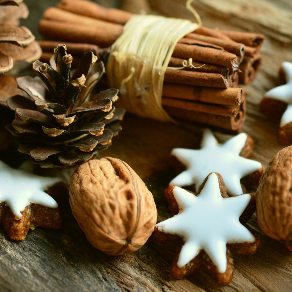 Печенье, орехи, палочки корицы и еловые шишки на деревянном столе
