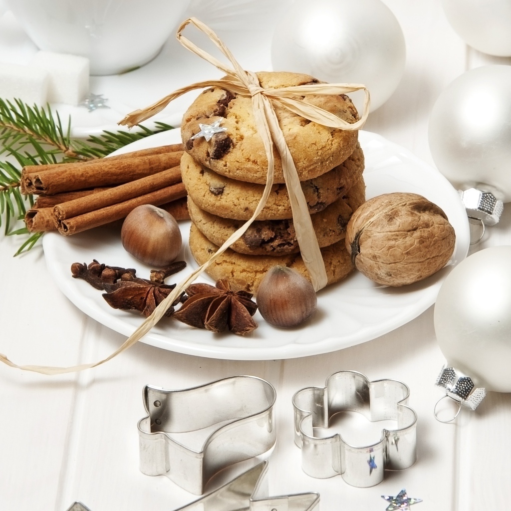 Печенье на тарелке с орехами и корицей на столе с игрушками 