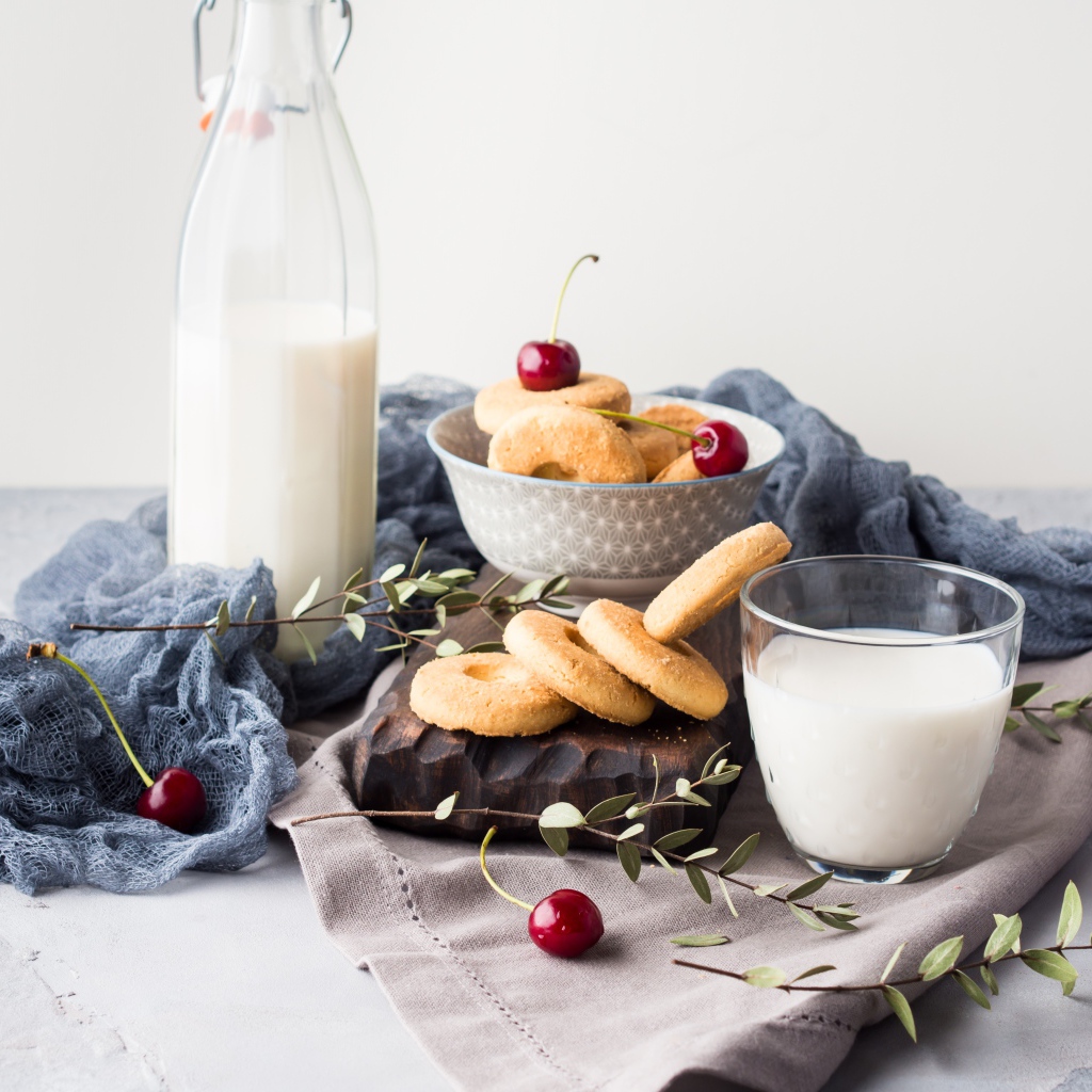 Печенье на столе с молоком и черешней