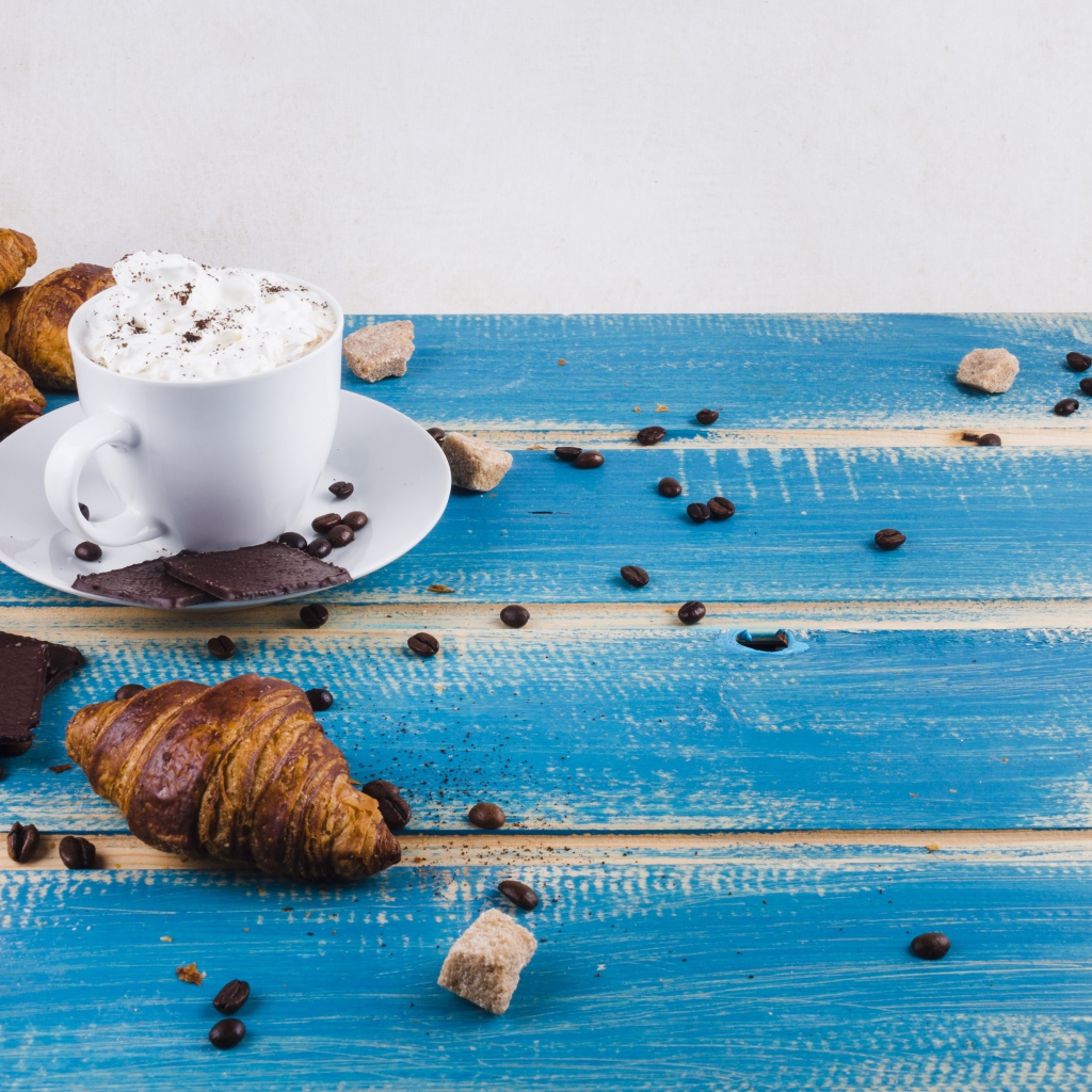 Круассаны на столе с напитком и шоколадом