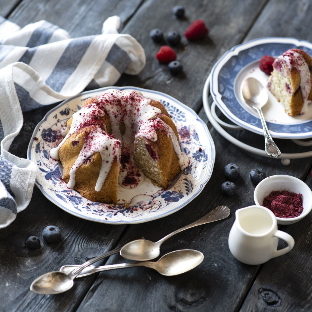 Кекс с кремом и ягодами на столе 